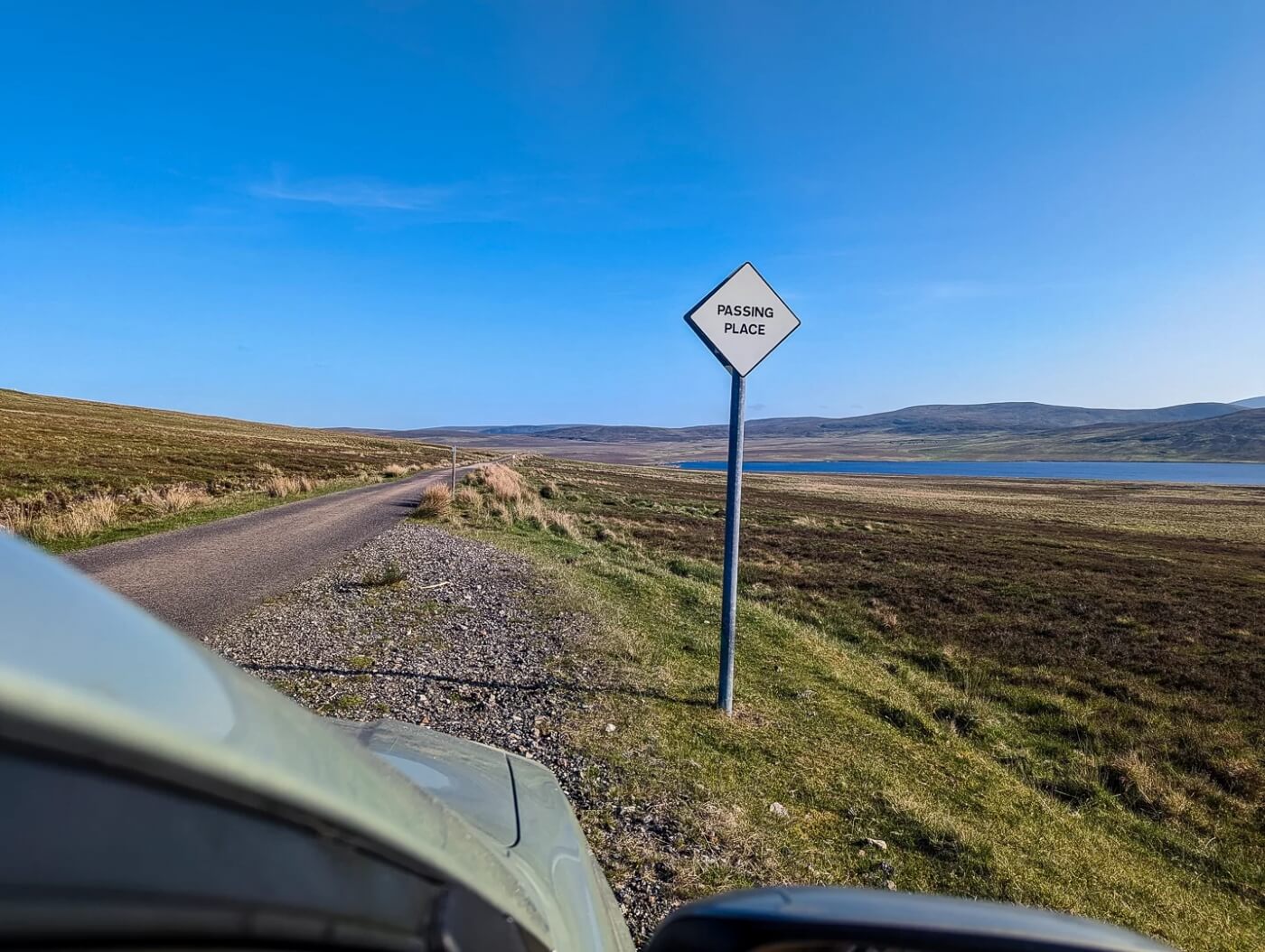 Segnale &ldquo;Passing Place&rdquo; nelle Highlands su strada single track accanto a un lago